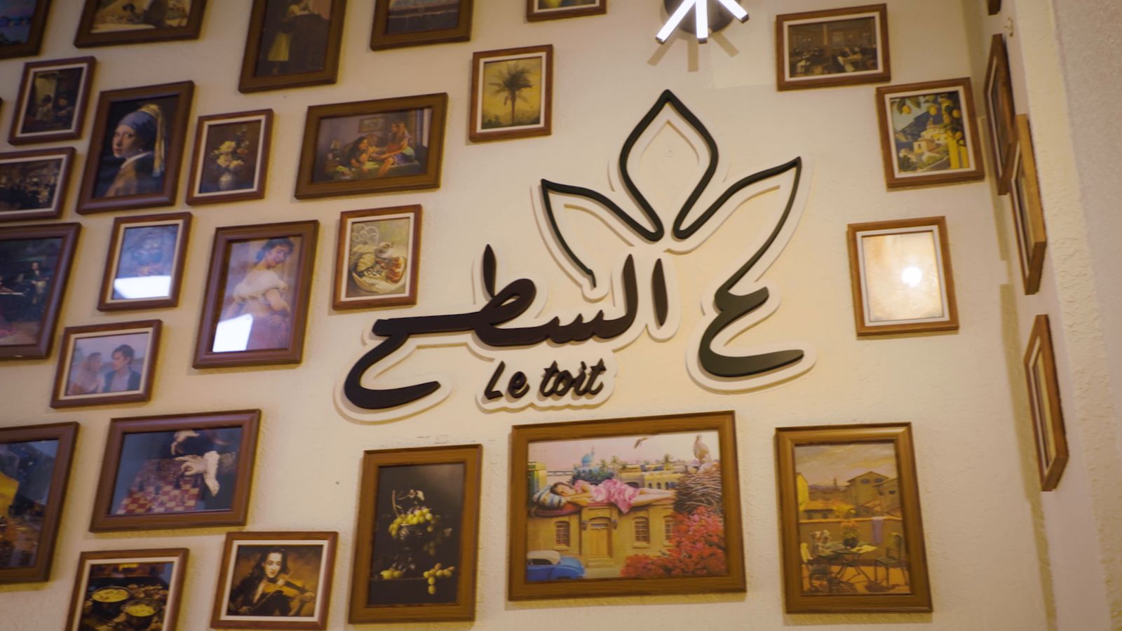 The Le Toit logo on a wall of framed paintings