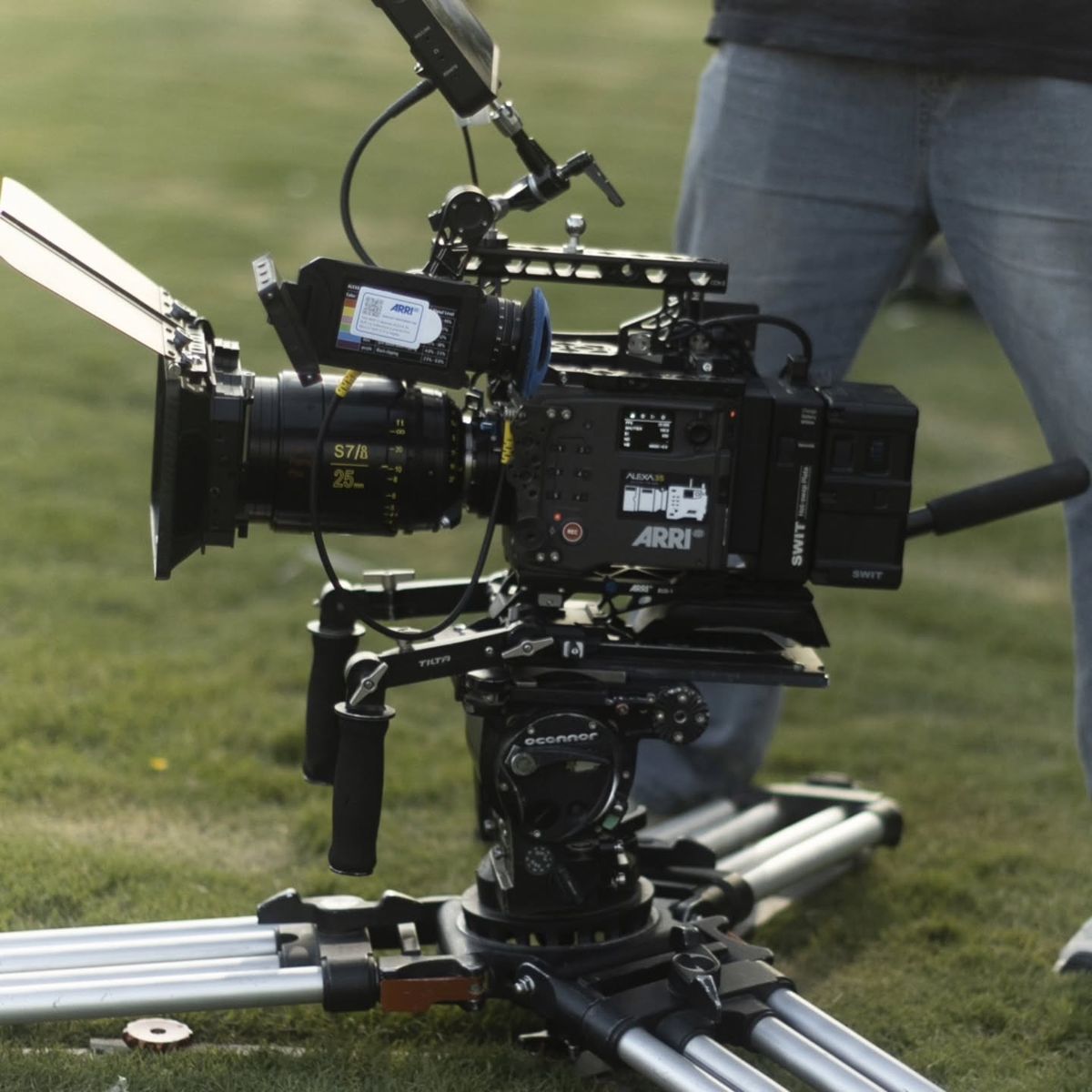 An ARRI ALEXA 35 camera on a dolly track on the grass