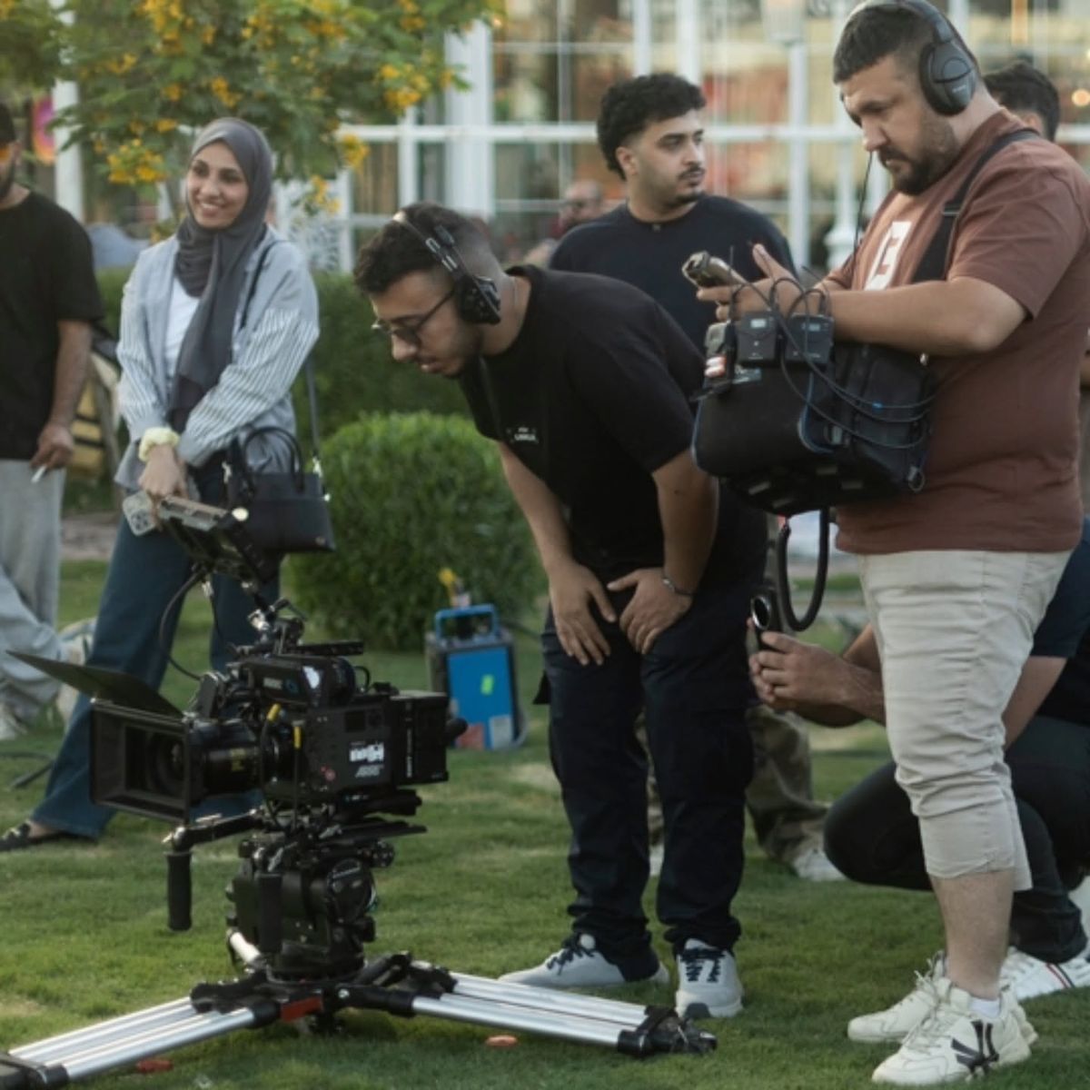 A crew gathered around a camera on the lawn