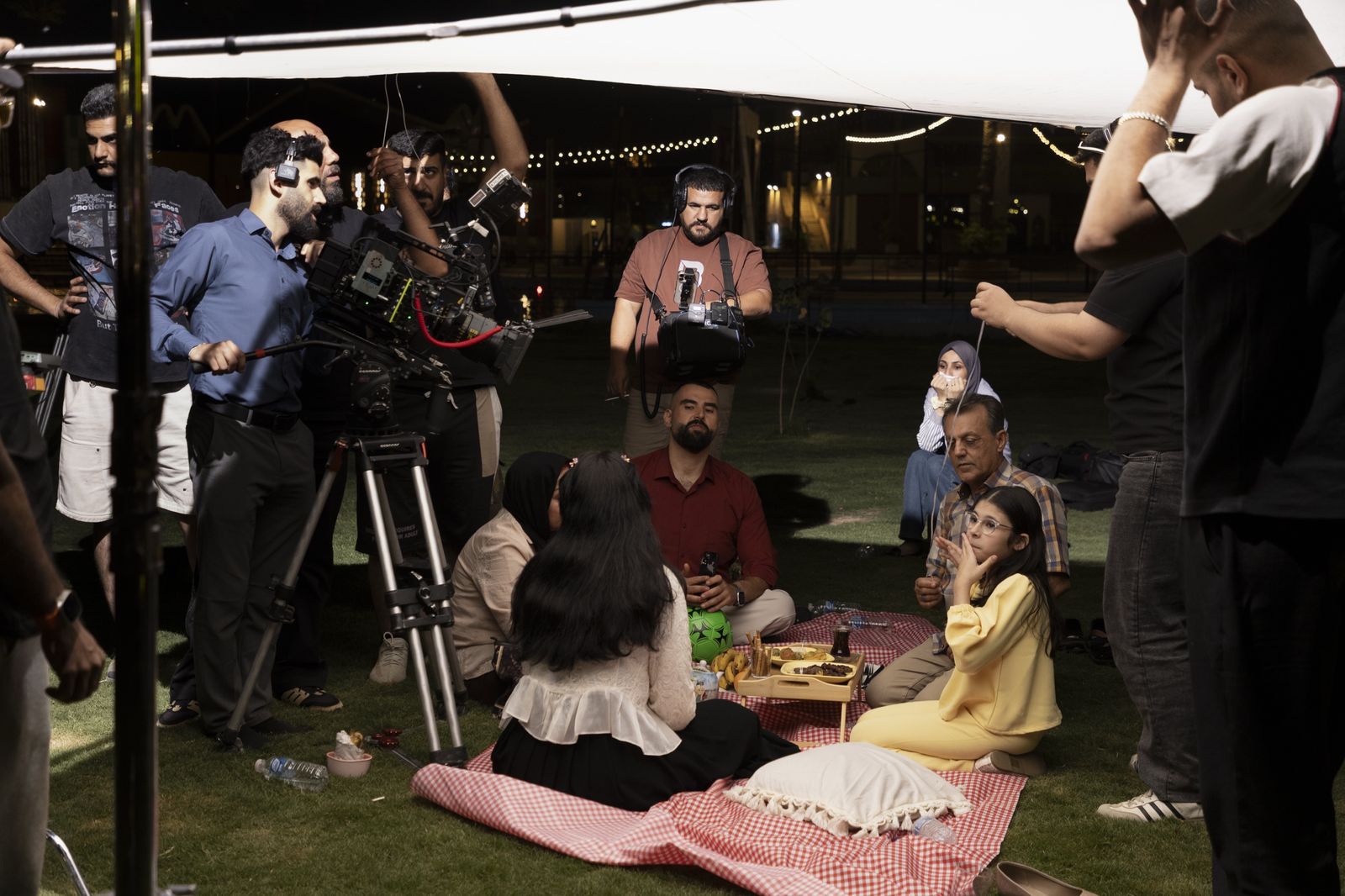 A night shoot of a family picnic scene under a white diffuser as the crew works