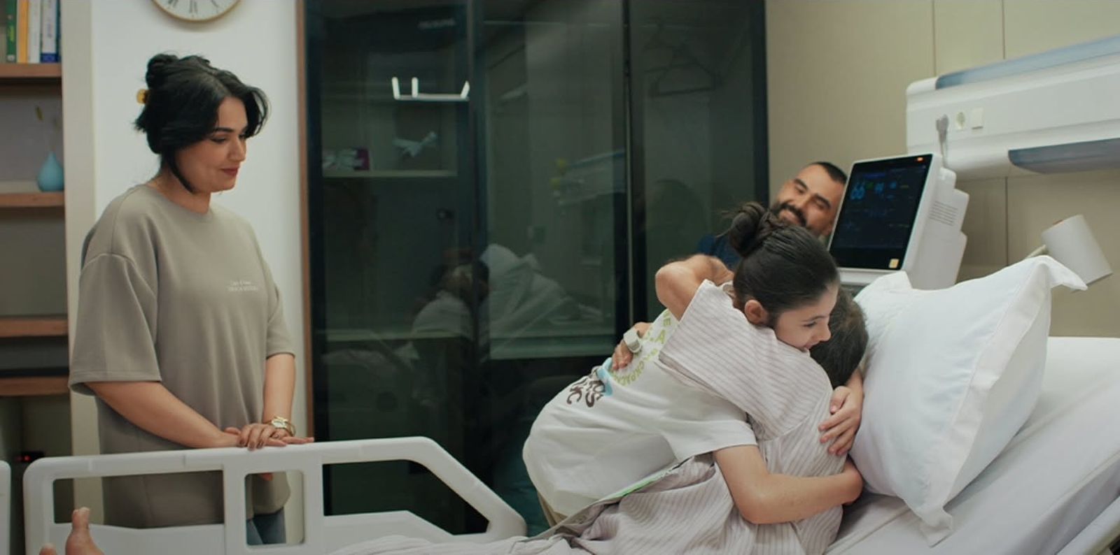 A girl hugging a patient as her family watches